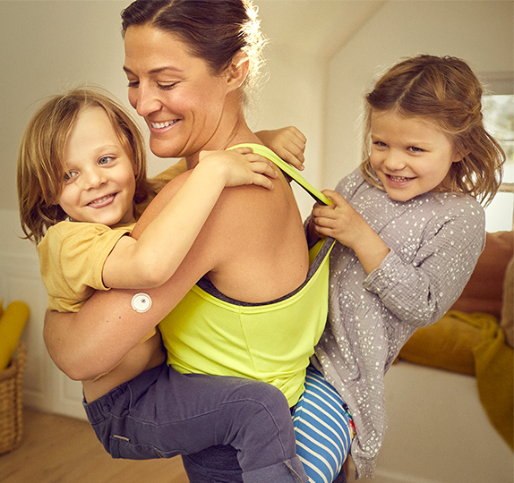 Woman playing with her kids while using the FreeStyle Libre 3 System